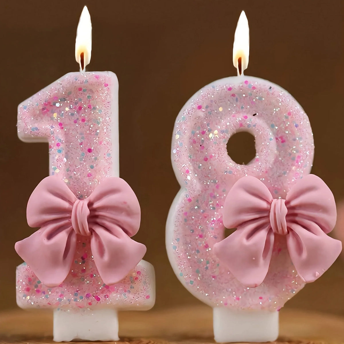 Pink glitter birthday candles shaped like the numbers 1 and 8