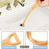 Una mano usa una herramienta flexible naranja para limpiar un desagüe de fregadero.
