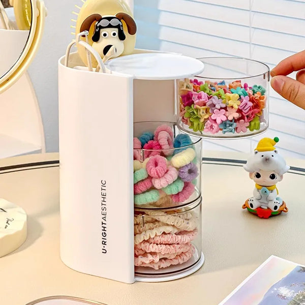A white acrylic rotating organizer holds various colorful hair accessories and makeup items.