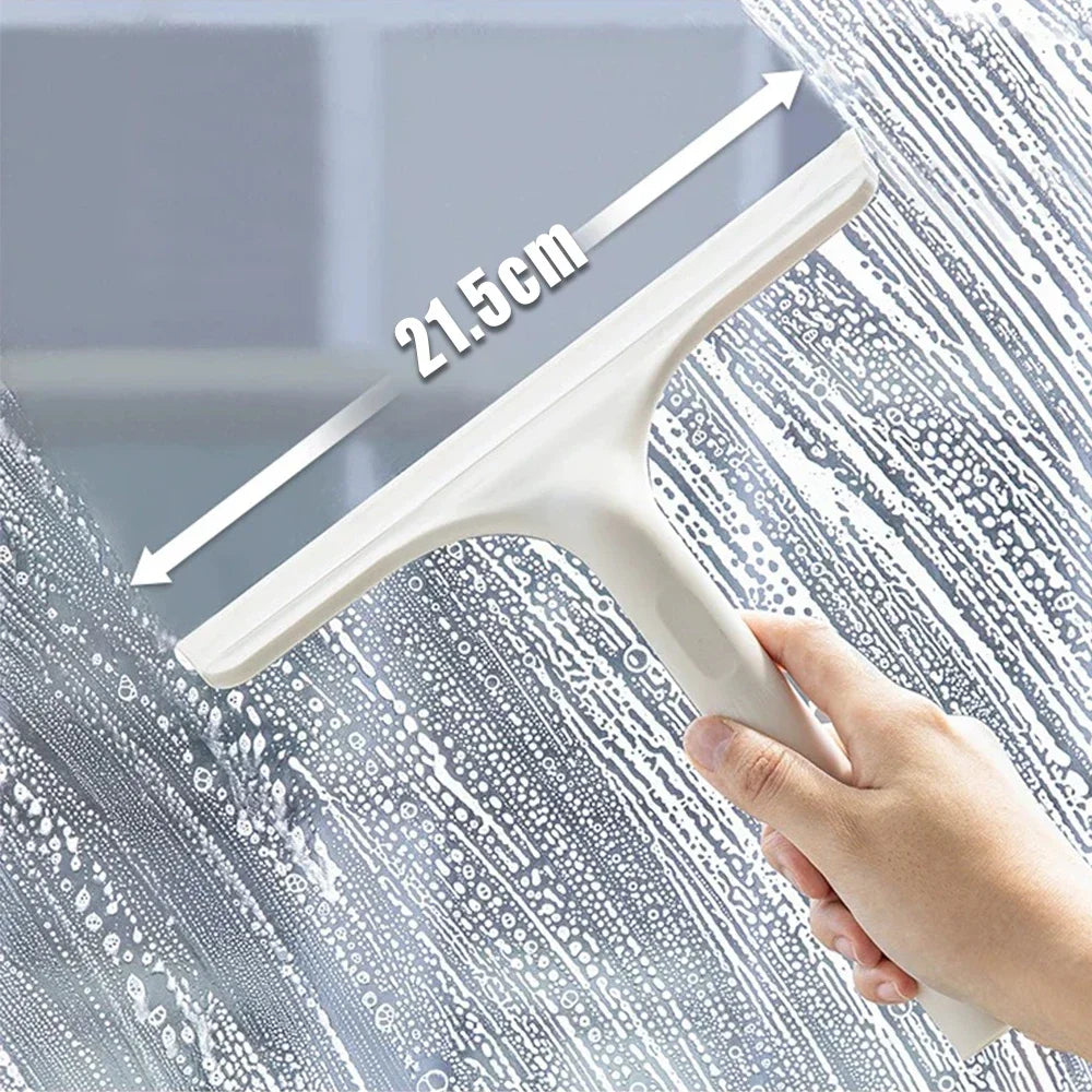Eine Hand benutzt einen weißen Fensterreiniger-Schaber mit einer Markierung von 21,5 cm auf einer Glasoberfläche.