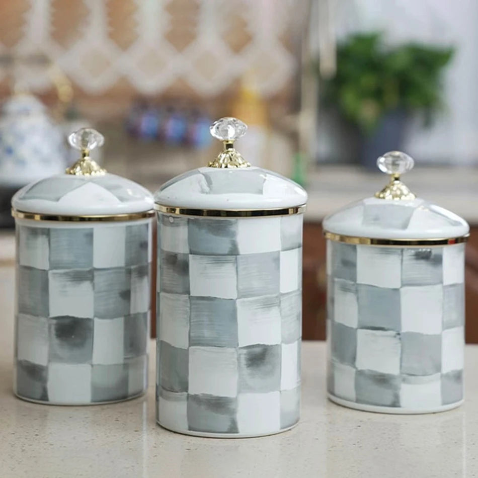 Three retro enamel storage jars with silver lids in gray and white checkered patterns.