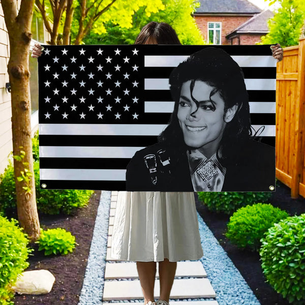 A woman stands in front of a black and white American flag banner featuring a portrait of a man.