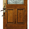 Nahaufnahme einer Holz-Tür mit Glaspaneel und einem antiken Silber-St. Benedikt-Medalons als Anhänger.