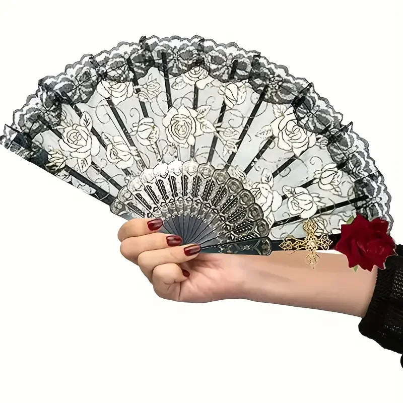 A hand holds a vintage Spanish flamenco rose lace handheld fan with intricate floral patterns.
