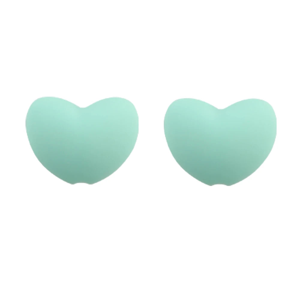 A pair of light mint green silicone heart-shaped charm beads for DIY jewelry.