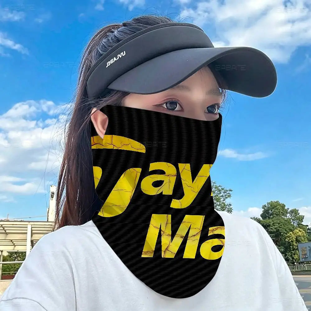A person wearing a black and yellow striped neck gaiter covering their lower face against a bright blue sky.
