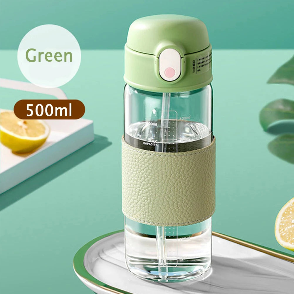 Tasse en verre portable verte avec une balance, à côté d'un citron, indiquant une capacité de 500ml.