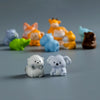 A collection of mini resin cartoon animal figurines in various colors including orange, yellow, blue, and brown.