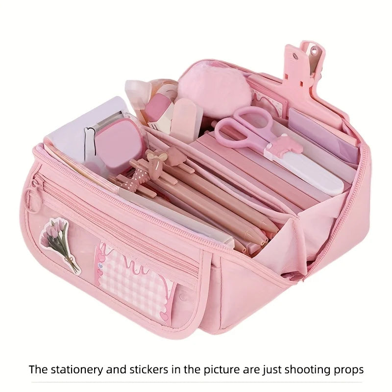 Pink multi-compartment pencil case organizer with various stationery and stickers inside