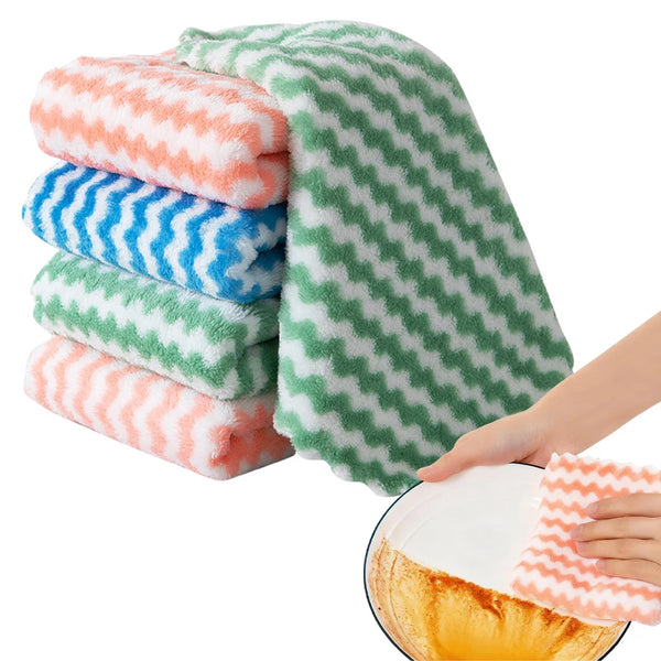 Stack of colorful microfiber kitchen dish cloths in orange, blue, and green textures being used to wipe a dish.
