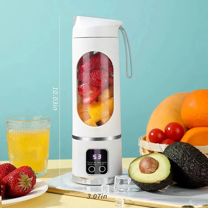 Licuadora eléctrica portátil blanca para zumbar frutas junto a fresas y una naranja sobre una superficie clara.