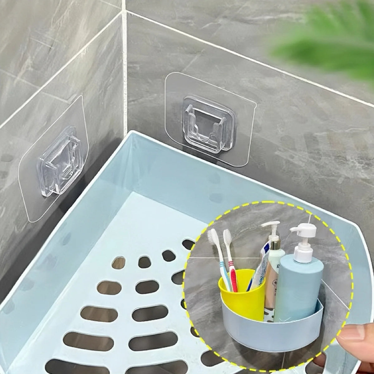 A set of clear double-sided adhesive wall hooks is shown mounted on a tile, with a yellow cup holding various grooming tools.