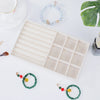 A velvet jewelry organizer tray with a drawer is shown with various beaded and gold jewelry items on a white surface.
