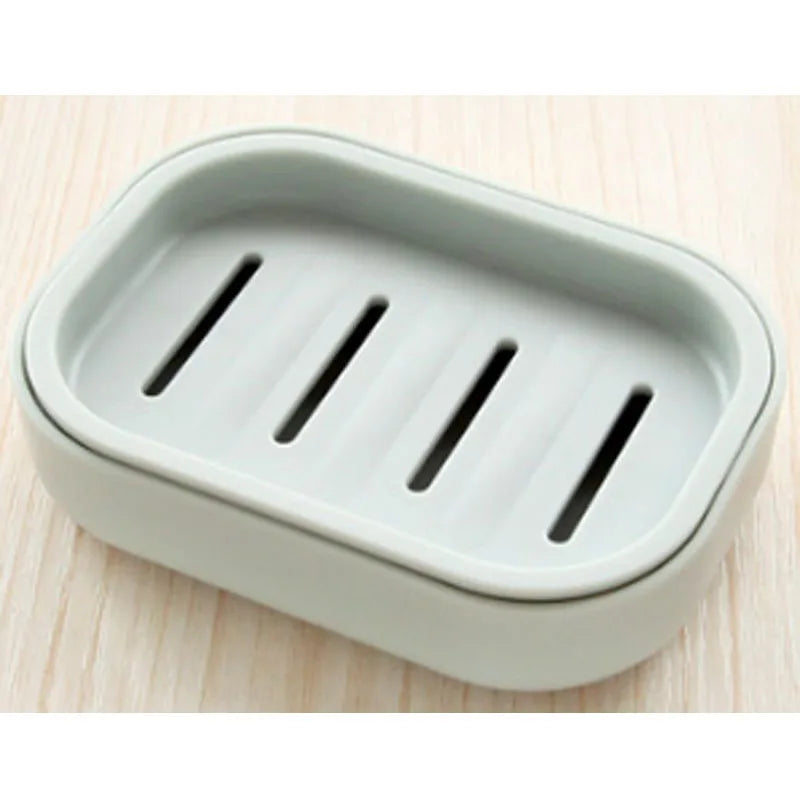 A rectangular, double-layer drain soap dish with three slots for holding soap.