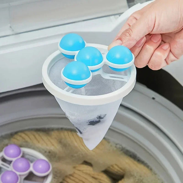A hand is placing blue silicone pet hair lint filter bags into a white mesh filter bag inside a washing machine drum.