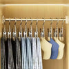 A row of gray and blue fabric hangers hanging on a stainless steel rod in a closet or storage area.
