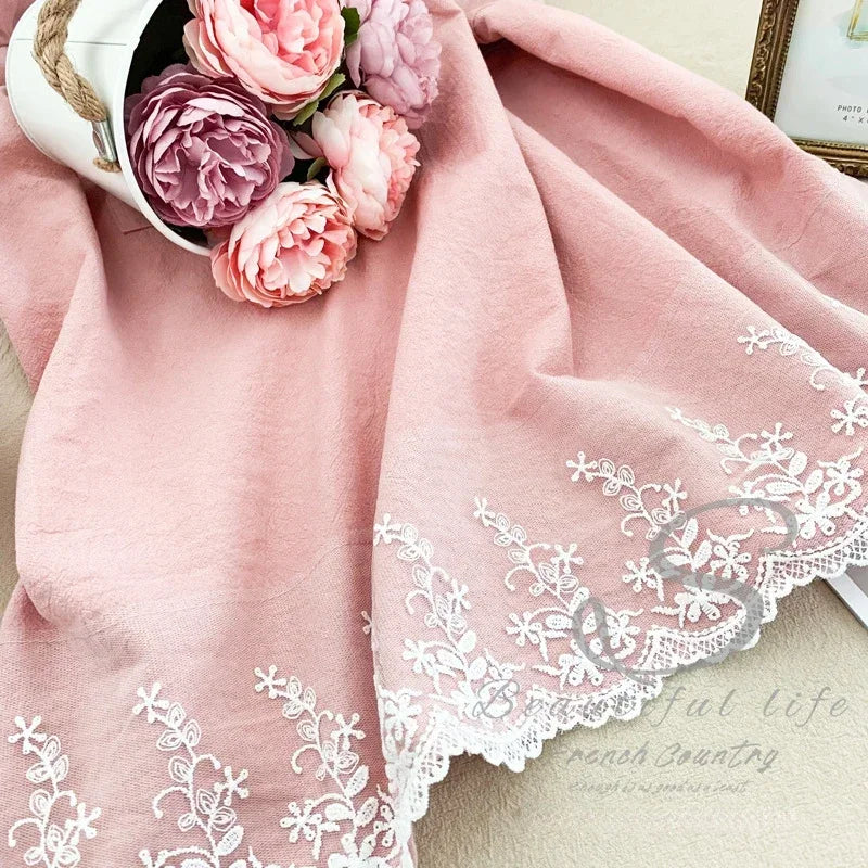 Rosa Leinen-Baumwoll-Apronkleid mit weißer Spitze und Blumenstickerei auf hellem Hintergrund