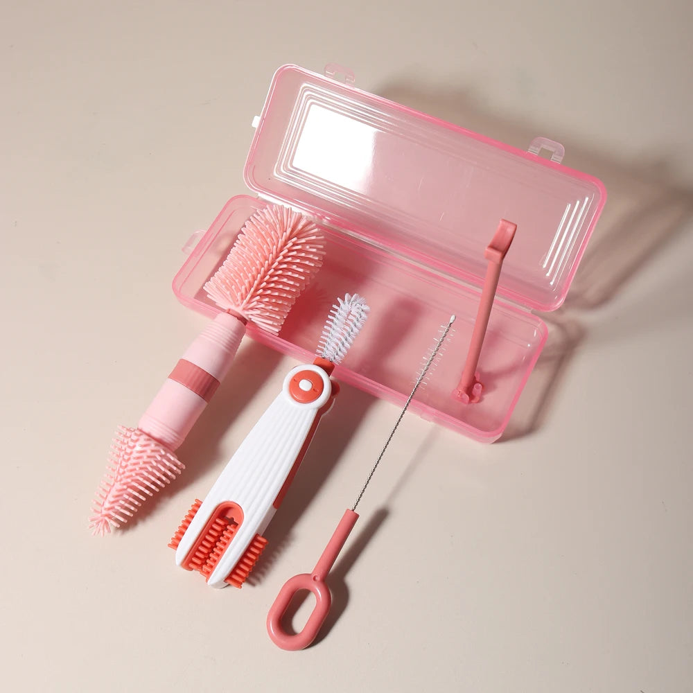 A pink silicone baby bottle cleaning set with a storage case, including a brush and a cleaning tool.