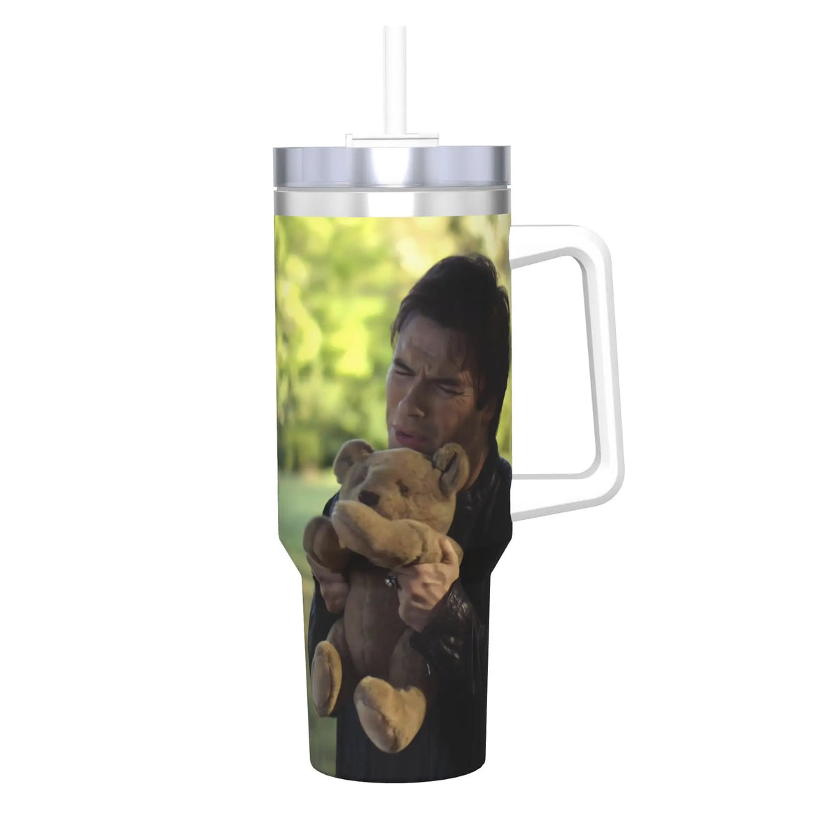 A clear tumbler filled with green liquid and a man holding a teddy bear.