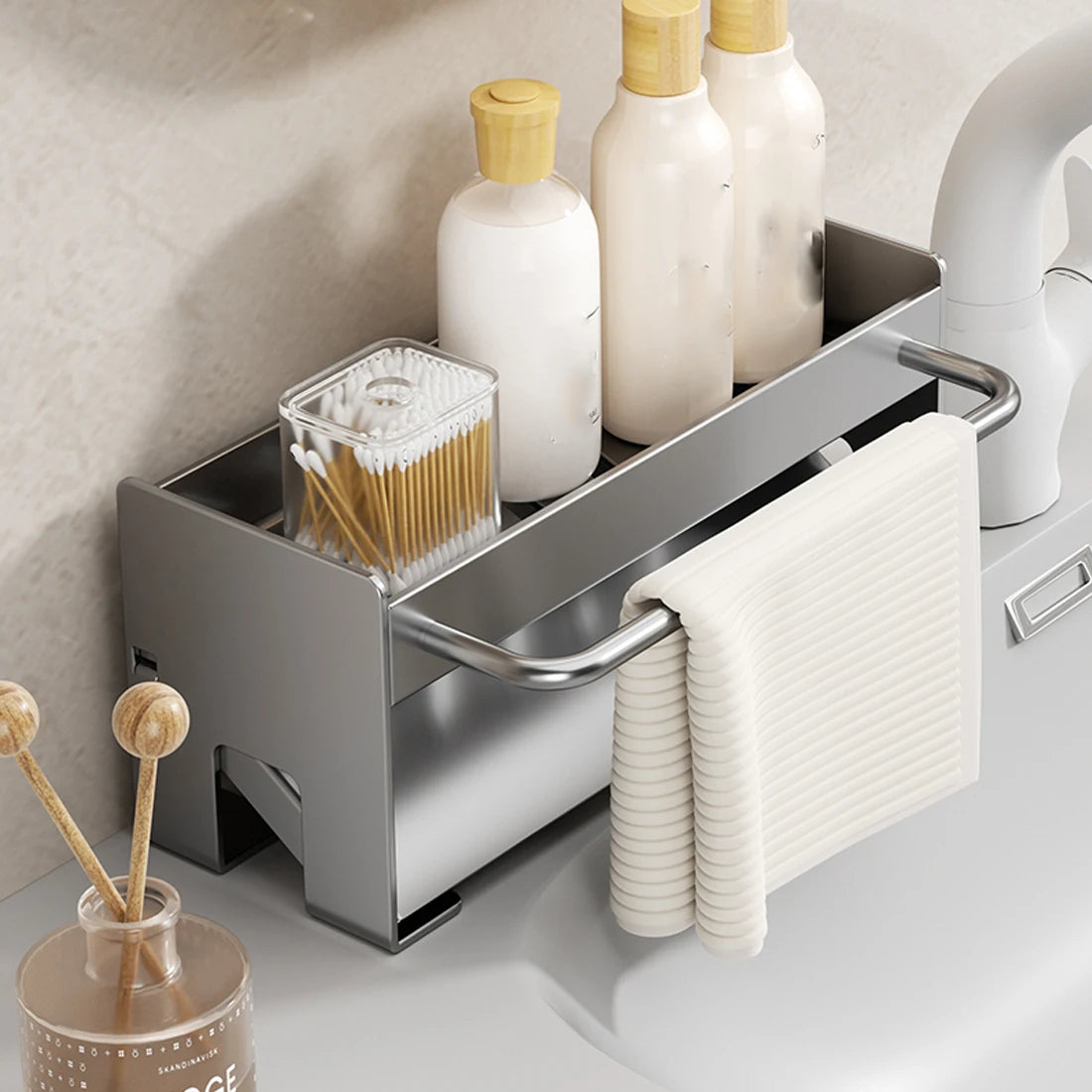 A stainless steel kitchen sink caddy holds various cleaning tools and bottles, including sponges and dish brushes.