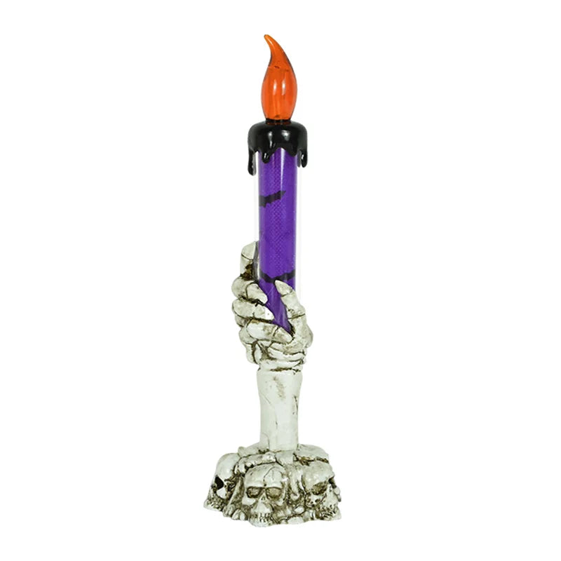 A skeleton hand sculpture holding a purple candle with an orange flame.