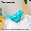 A vibrant turquoise crystal bird statue made of natural crystal fragments bonded with resin resting on a white rock.