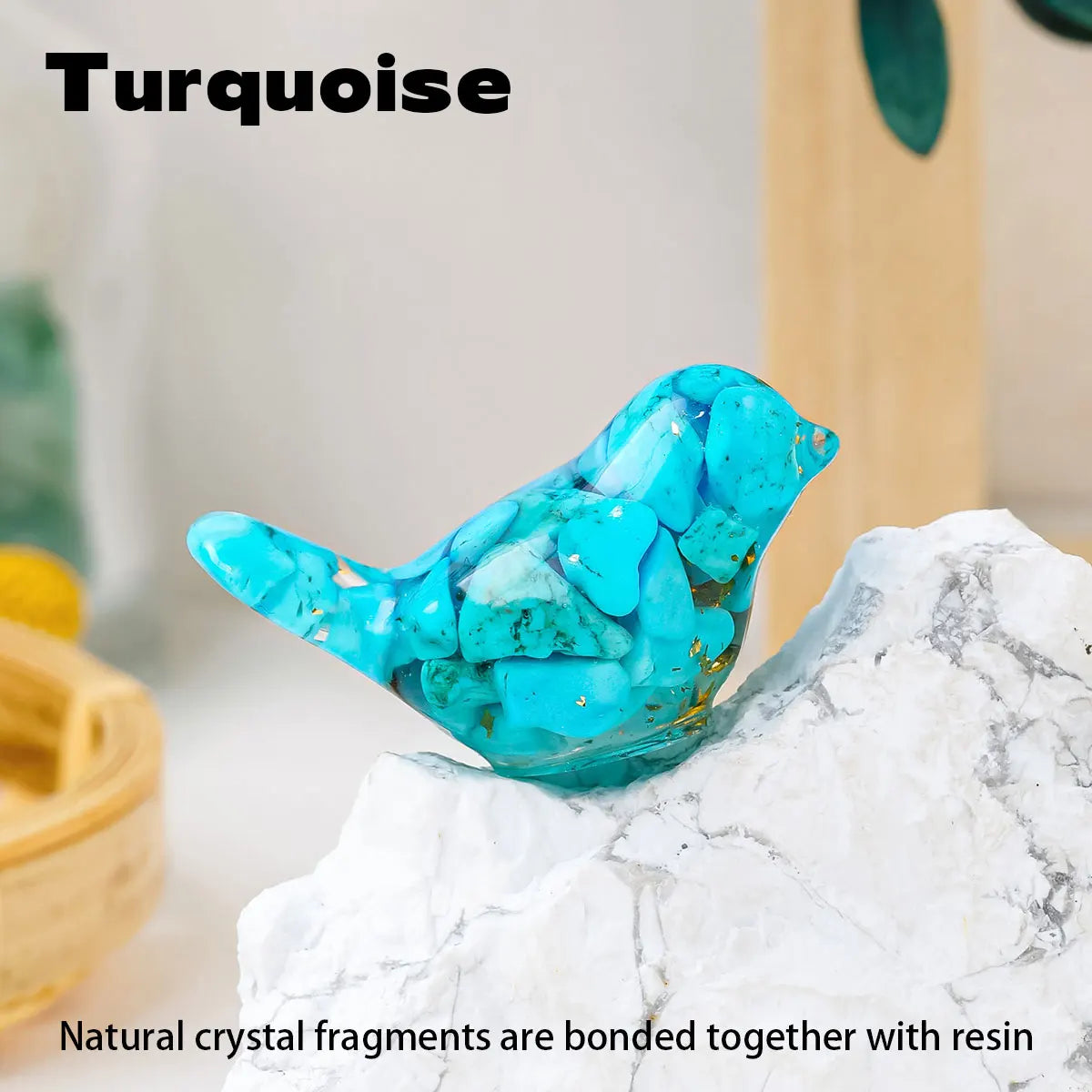 A vibrant turquoise crystal bird statue made of natural crystal fragments bonded with resin resting on a white rock.