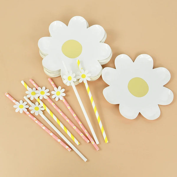 A set of white floral disposable party decor including flower-shaped plates and striped wooden sticks.