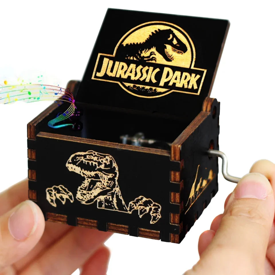 An antique wooden hand crank music box with a Jurassic Park themed lid and dinosaur silhouette inside.