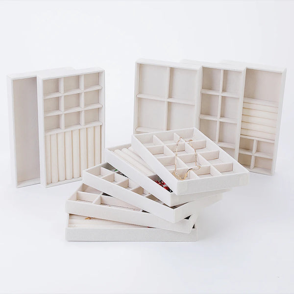 A set of white velvet jewelry organizer trays and drawers displayed on a white background.