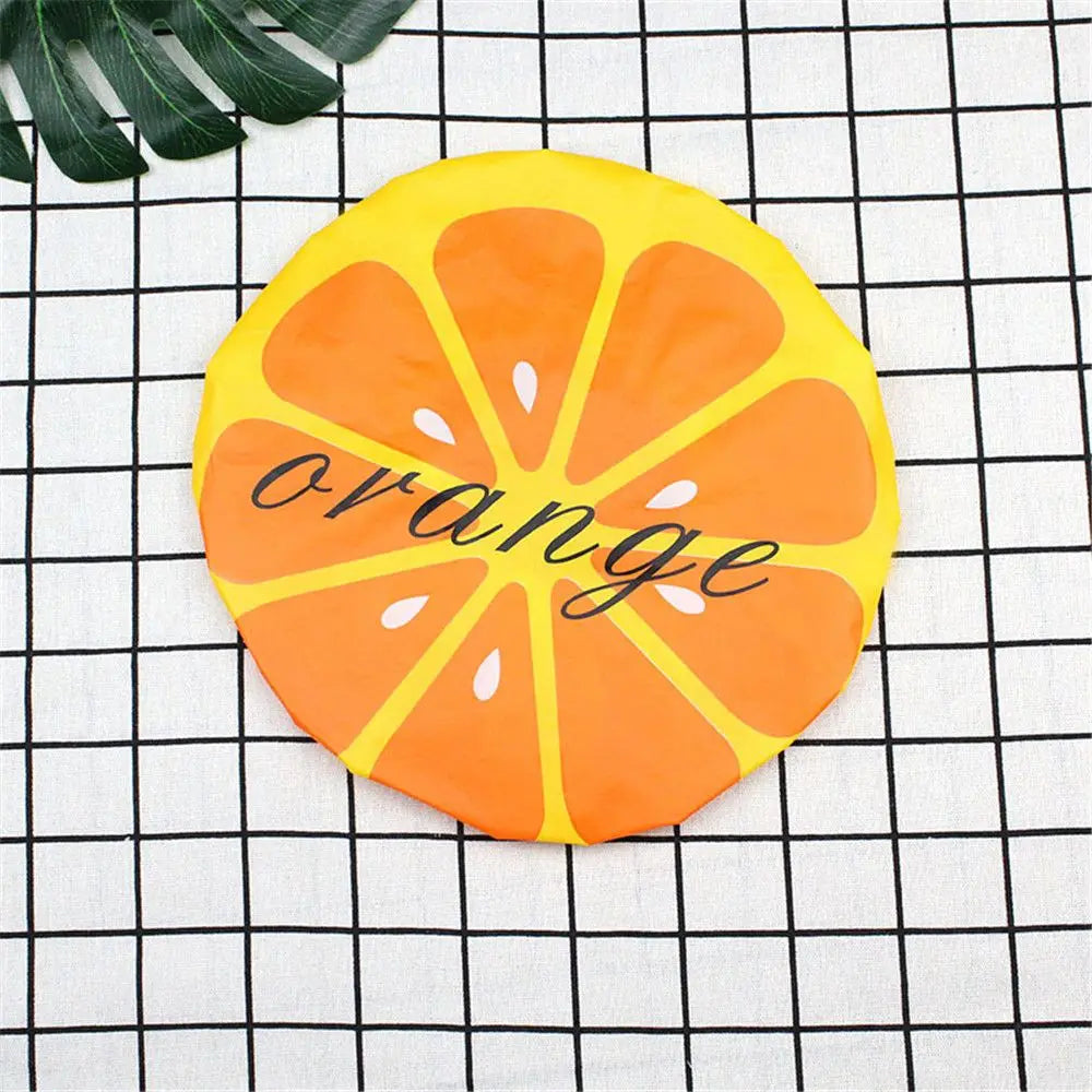 A bright orange citrus slice design on a yellow background used as a reusable fruit shower cap.