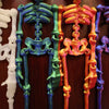 A collection of luminous magnetic poseable skull fridge magnets in white, teal, and orange colors.