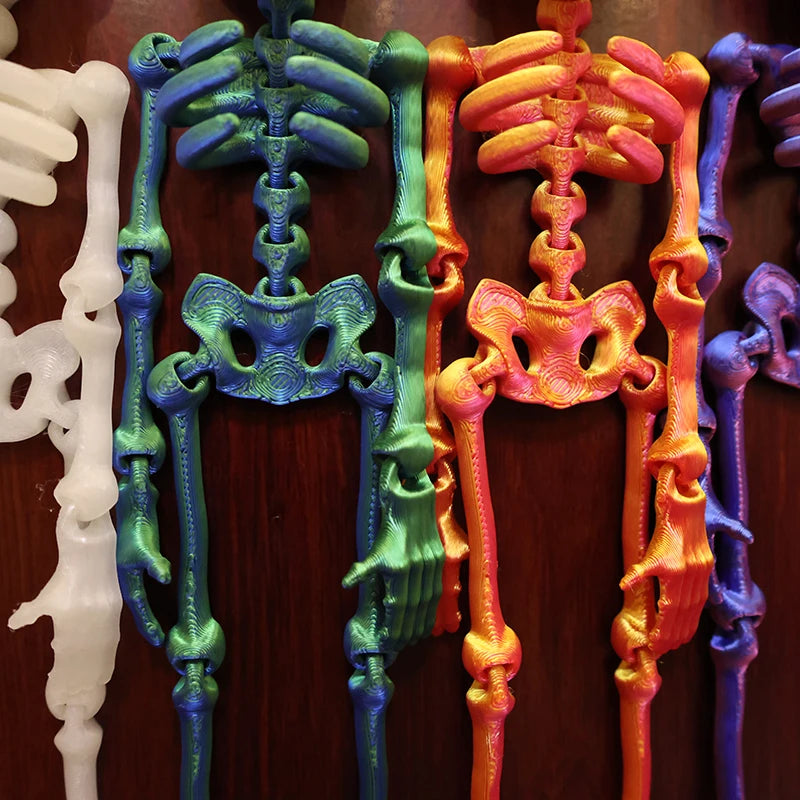 A collection of luminous magnetic poseable skull fridge magnets in white, teal, and orange colors.