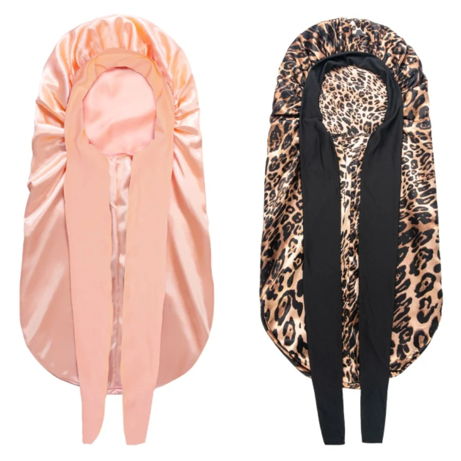A satin sleep bonnet in peach color shown on the left and a black leopard print bonnet on the right.
