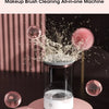 A makeup brush cleaning all-in-one machine with a clear glass container and a pink base, showing water spray.