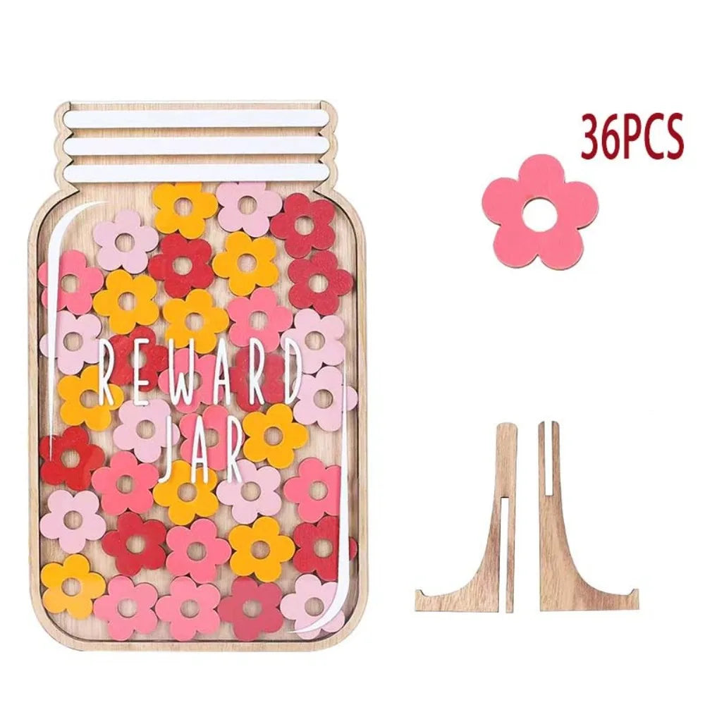 A wooden behavior reward jar filled with pink and orange flowers and includes two wooden flower pickers.