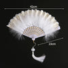 White lace fabric folding hand fan with gold accents and a decorative tassel