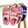 A set of portable plastic wig hangers in pink and purple colors hanging on a wooden rod.