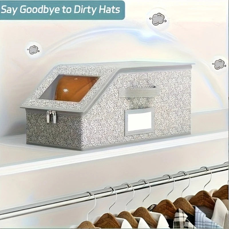 A gray fabric hat storage box with a window and zipper is displayed on a shelf.