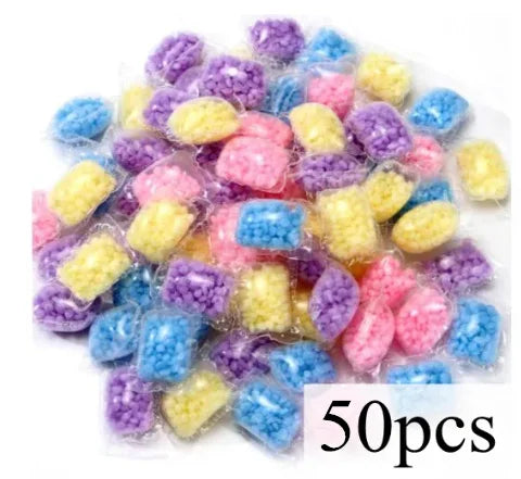 A pile of colorful laundry fragrance beads in various shades of purple, blue, and yellow.