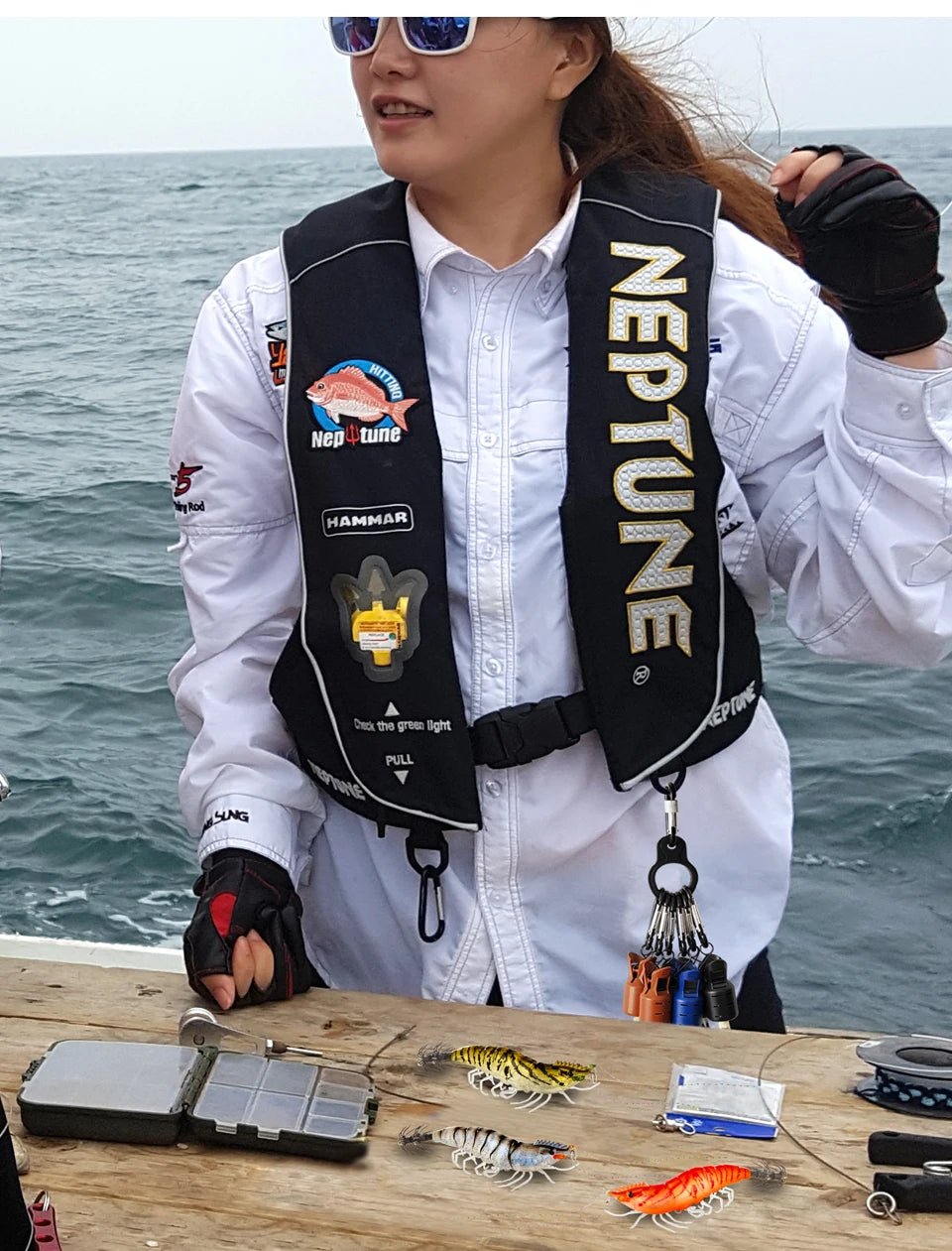 A person holds an octopus lure bait protector kit with various lures and accessories on a wooden surface.