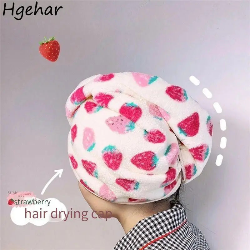 A pink and white strawberry print quick-drying hair drying cap worn by a person.