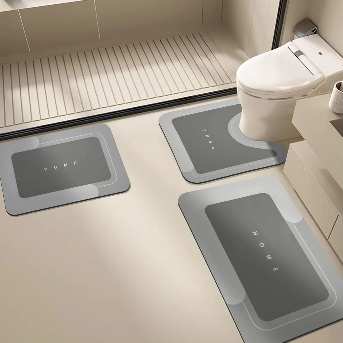 Three rectangular gray floor mats are placed on a light beige floor near a toilet.