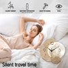 Une horloge murale au design lunaire moderne posée sur des draps blancs à côté d'une femme endormie.