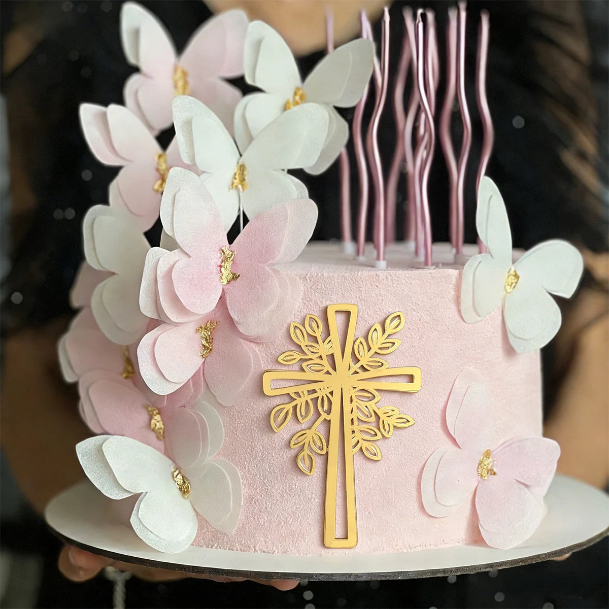 Pink and white floral cake decorated with gold acrylic cross toppers
