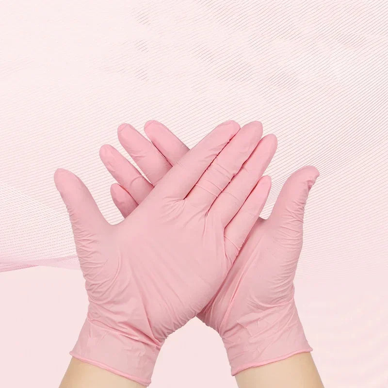 A pair of pink disposable nitrile gloves are shown, folded together against a light pink background.
