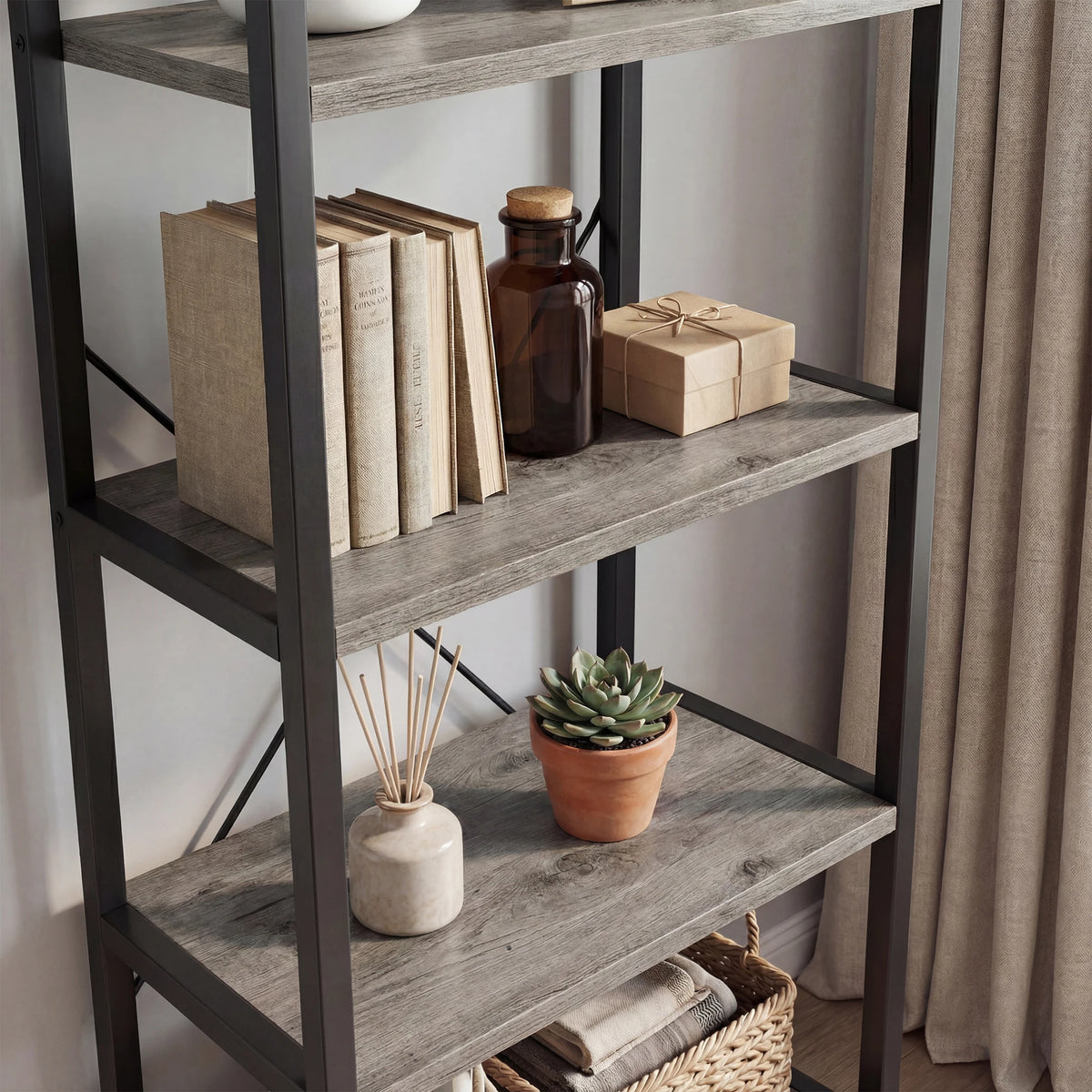 A dark metal bookshelf with three shelves displaying books, a glass jar, and a succulent plant.