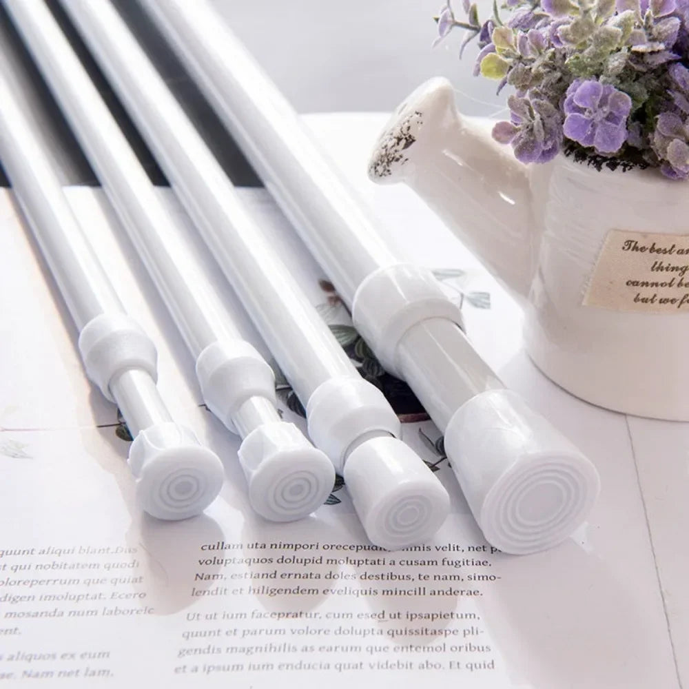 A close-up of a white adjustable telescopic curtain rod with decorative finials, set against a light background.