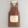 A brown striped sleeveless kitchen apron with a removable beige hand towel hanging on a wooden hanger.