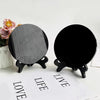 A black obsidian scrying mirror decor with a round, reflective surface is displayed on a white background.